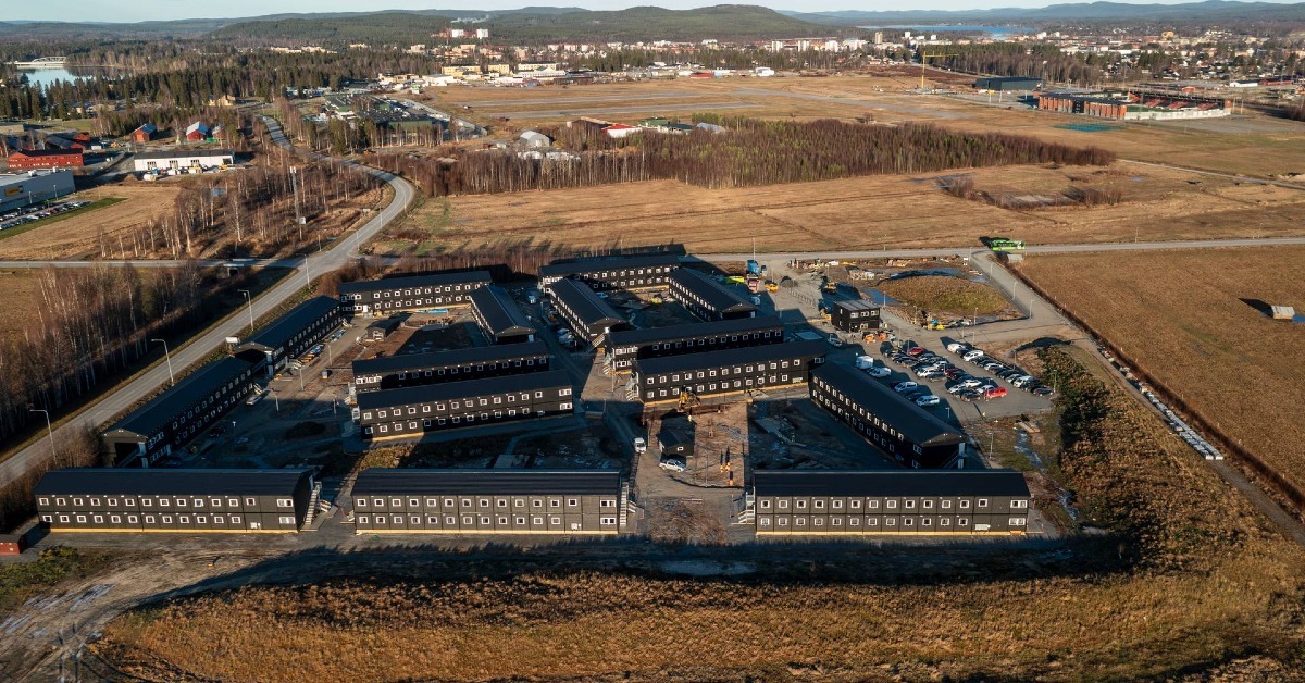 Aerial view of a temporary worker accommodation with multiple modular buildings arranged around internal roads and outdoor work areas.